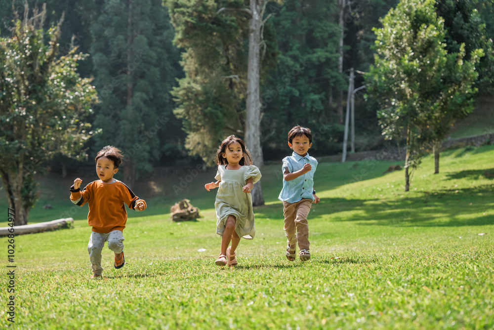 Three joyful and happy children are playing together joyfully in a beautiful outdoor setting Three joyful and happy children are playing together joyfully in a beautiful outdoor setting