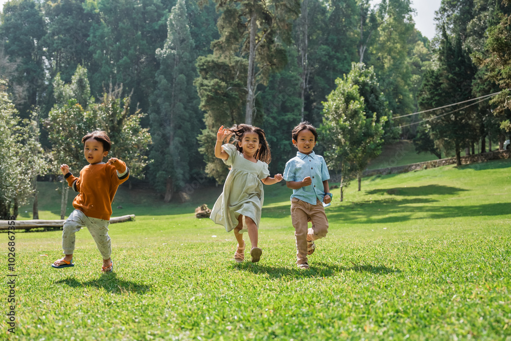 Obraz premium Children are playfully running around in a colorful and vibrant green park, enjoying life