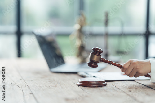 Gavel of Justice: A closeup of a lawyer's hand holding a wooden gavel, poised to strike, symbolizes the power and finality of legal decisions.
