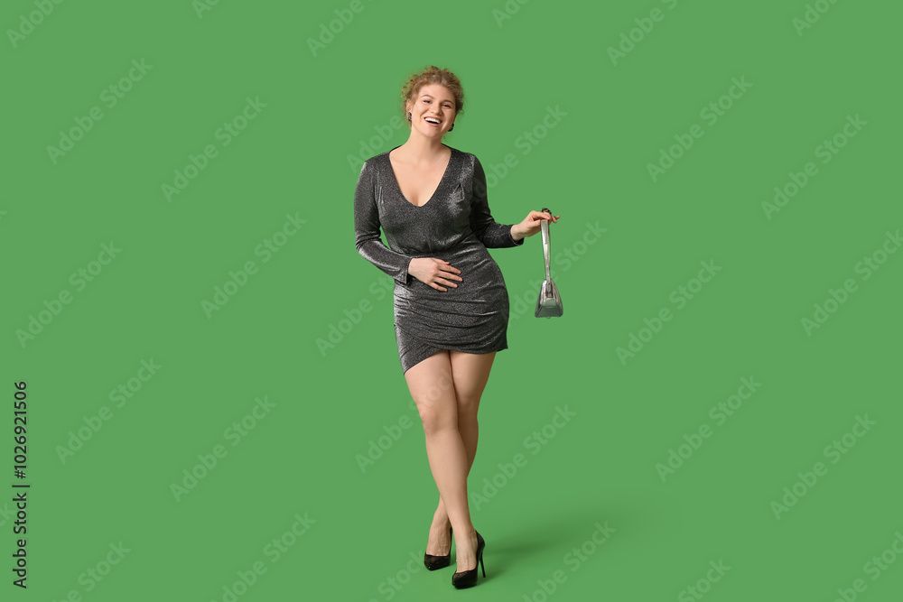 Beautiful young woman in stylish dress with handbag on green background Beautiful young woman in stylish dress with handbag on green background