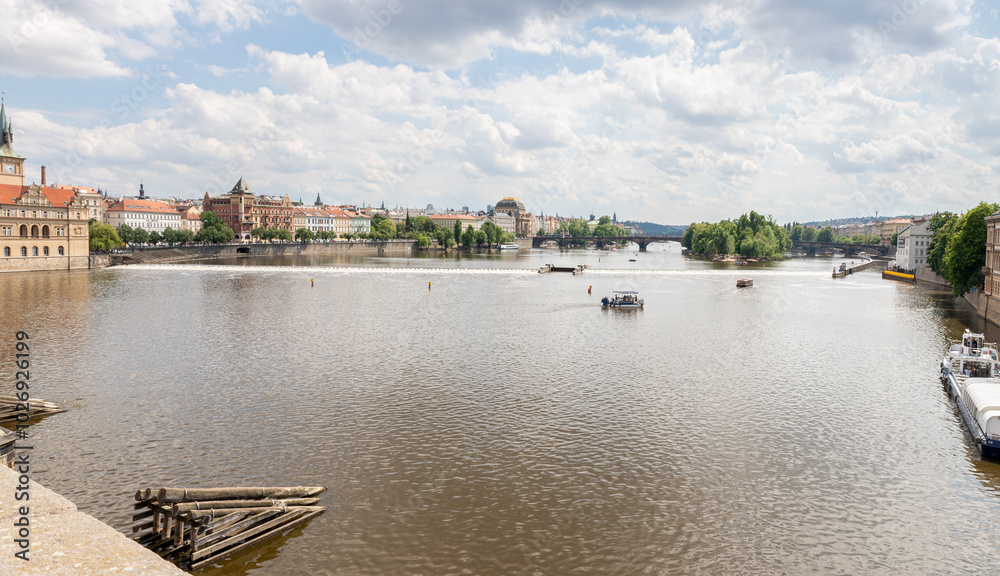 Obraz premium View from Charles Bridge to the Vltava river and banks with historical buildings in Prague in Czech Republic