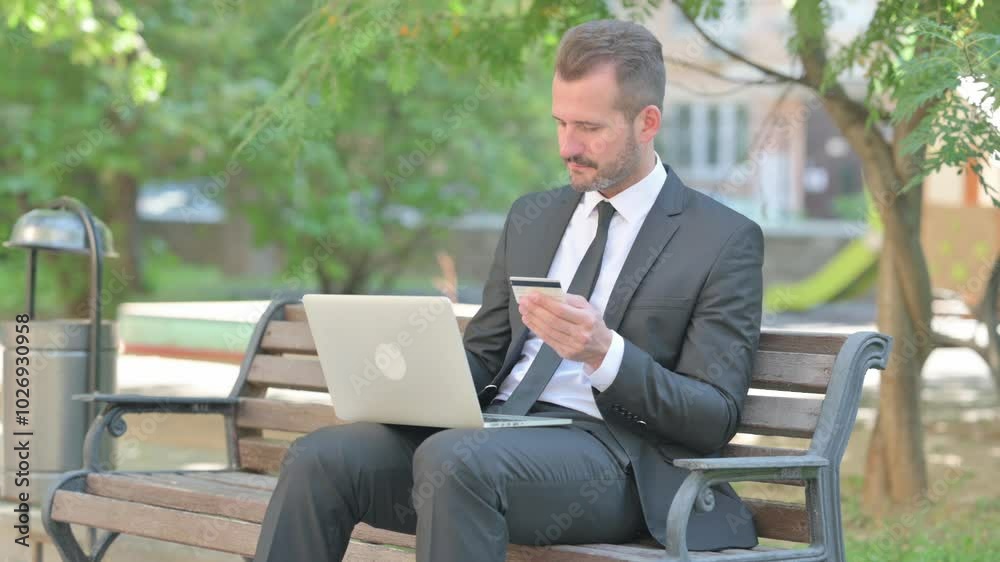 Middle Aged Businessman Enjoying Online Banking with Credit Card Outdoor
