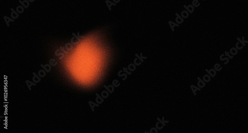 Orange dot on black abstract grainy texture background