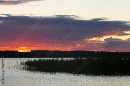 Dramatischer Himmel beim Sonnenuntergang am See in Schweden. photo