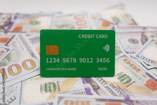 Green credit card laid on a background of scattered US bills, symbolizing financial growth, sustainability, and wealth management.