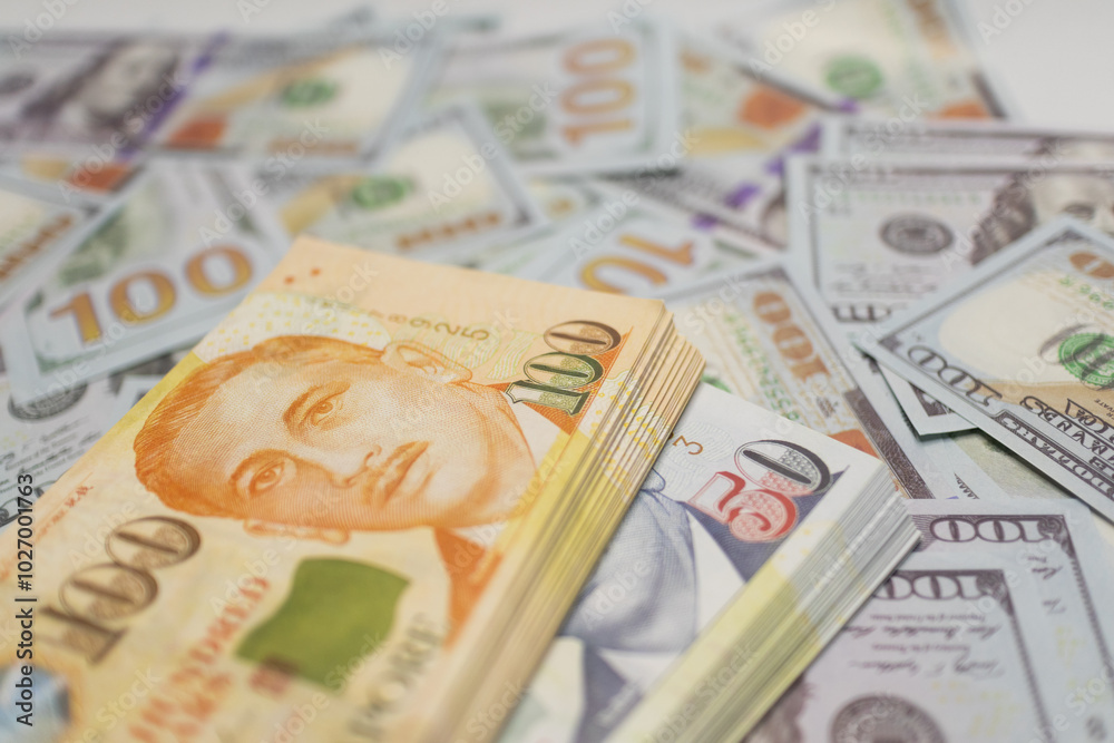 OrangeSingapore dollar bills stacked on US dollars, symbolizing currency exchange and financial transactions Ideal for business and finance visuals. OrangeSingapore dollar bills stacked on US dollars, symbolizing currency exchange and financial transactions Ideal for business and finance visuals.