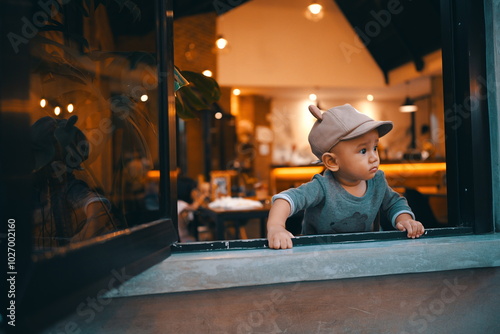 A young child peeks curiously from a caf window, capturing a moment of wonder