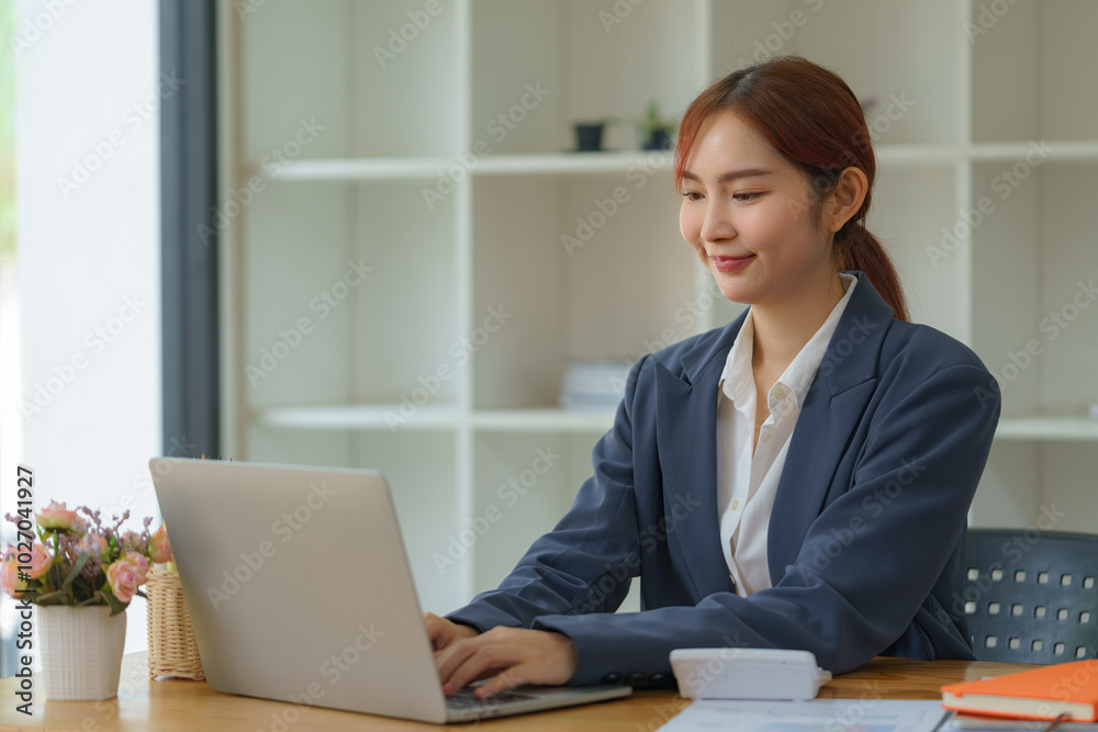 Asian businesswoman working with a laptop at the office. Asian businesswoman working with a laptop at the office.
