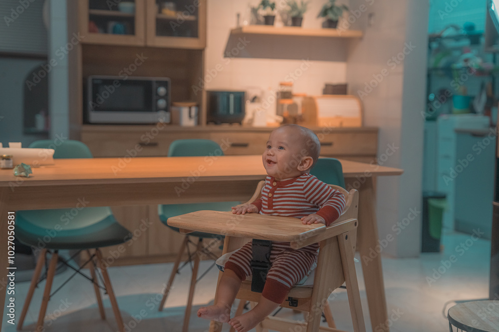Fototapeta premium A cheerful and happy child is sitting comfortably in a high chair in a stylish kitchen design