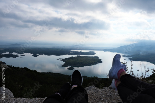 Legs of a couple of people in sneakers against the background of morning mountains