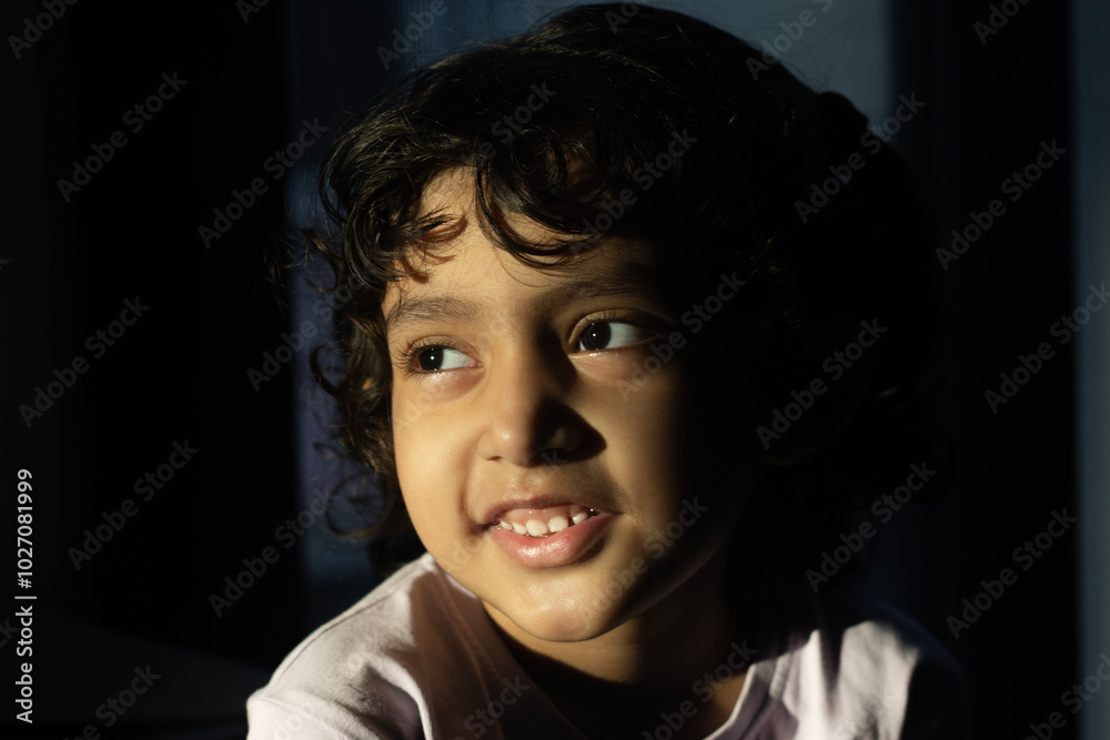 Cute girl child with smiling face and sun light glowing her face in dark. Cute girl child with smiling face and sun light glowing her face in dark.