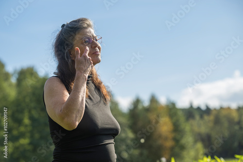 Eine ältere Frau streicht sich die Haare aus dem Gesicht photo