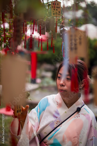 A Woman in Kimono Contemplates the Ema on the Wish Tree Beneath the Torii Gate