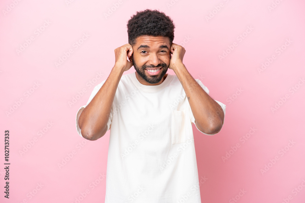 Young Brazilian man isolated on pink background frustrated and covering ears Young Brazilian man isolated on pink background frustrated and covering ears