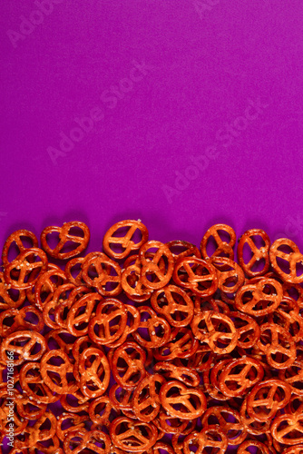 Border of mini pretzels on purple background. Vibrabt color backdrop with Savory twists photo