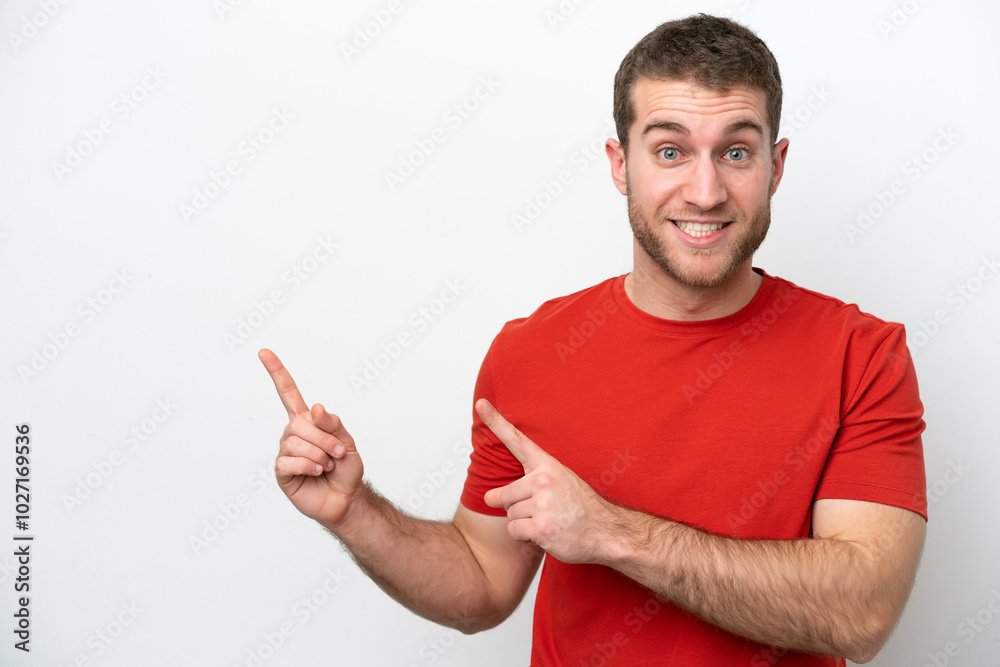 Young caucasian man isolated on white background frightened and pointing to the side