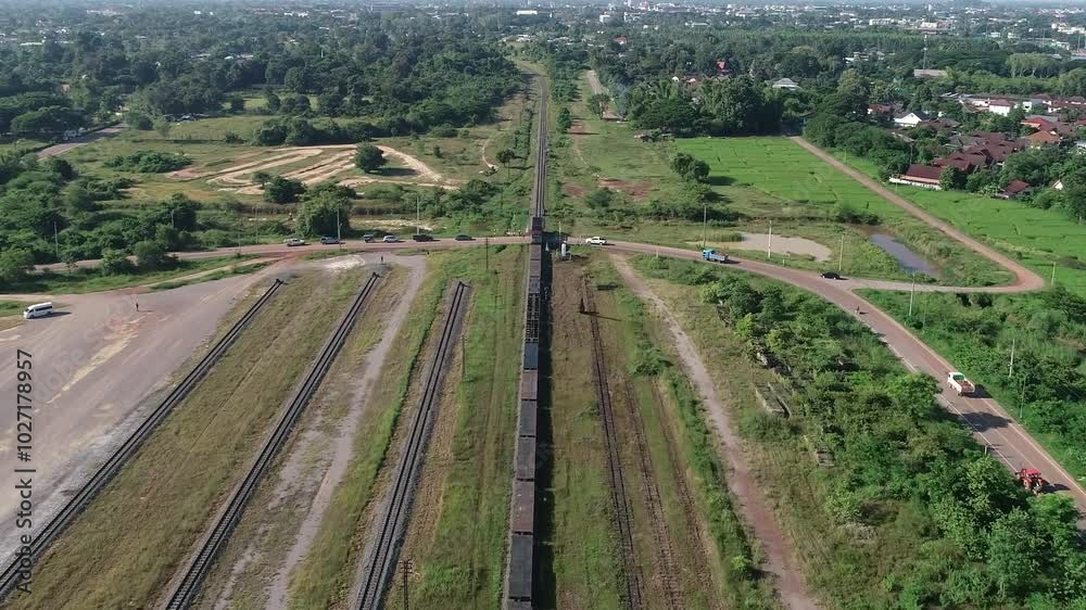Aerial View of Train Passing Through Greenery and Suburban Landscape Aerial View of Train Passing Through Greenery and Suburban Landscape