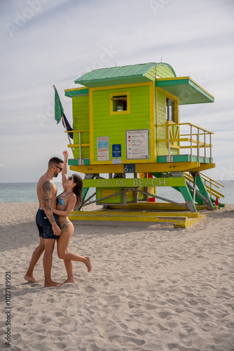 Couple in love enjoying themselves in front of a lifeguard stand in Miami Beach.