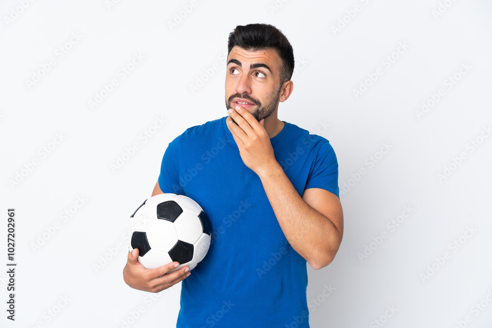 Handsome young football player man over isolated wall looking up while smiling Handsome young football player man over isolated wall looking up while smiling