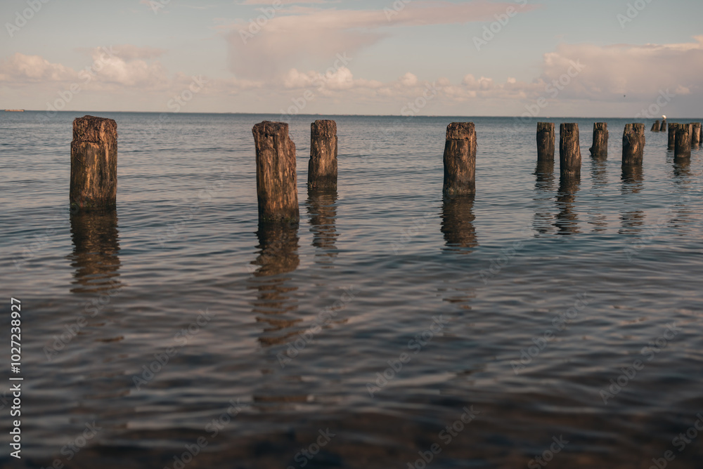 the remains of an old wooden bridge into the sea on an autumn evening the remains of an old wooden bridge into the sea on an autumn evening
