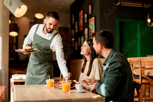 Waiter serves delicious vegetarian dishes to cheerful diners in a vibrant café during a sunny afternoon