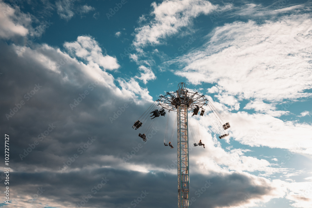 People riding swing chair ride at carnival People riding swing chair ride at carnival