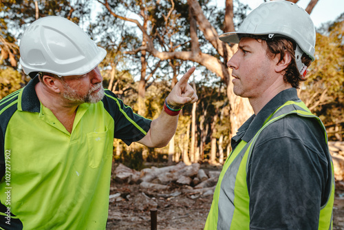 Two building contractors in heated argument at the construction site boss pointing finger at worker