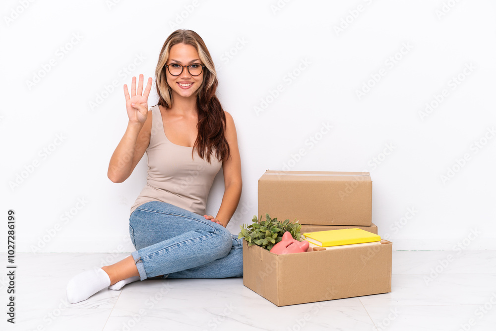 Young Russian girl sitting on the floor isolated on white background happy and counting four with fingers Young Russian girl sitting on the floor isolated on white background happy and counting four with fingers