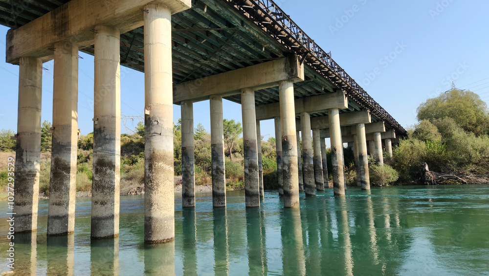 Fototapeta premium The columns of a reinforced concrete road bridge over a river