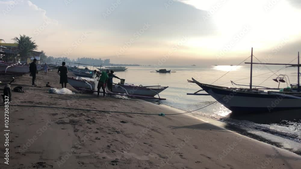 Beautiful view of the morning activities of the fishermen and residents on the beach by the sea at sunrise. Beautiful view of the morning activities of the fishermen and residents on the beach by the sea at sunrise.