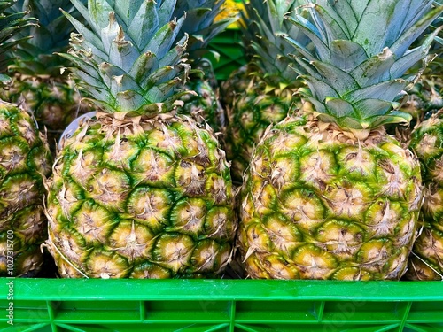 Close up image of two ripe pineapples on a basket in a grocery store for sale