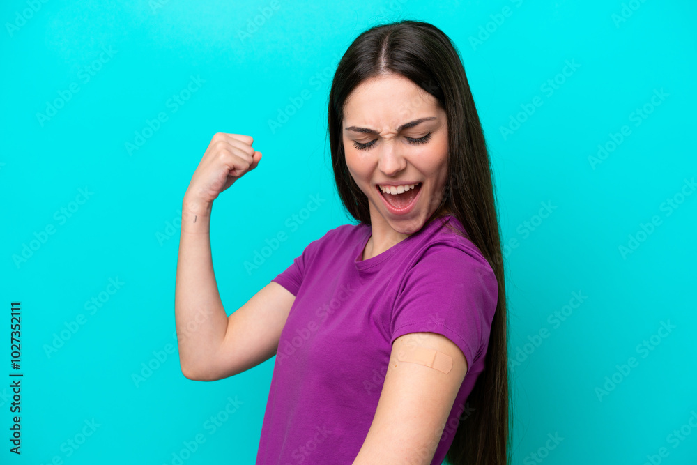 Young girl with band-aids isolated on blue background celebrating a victory