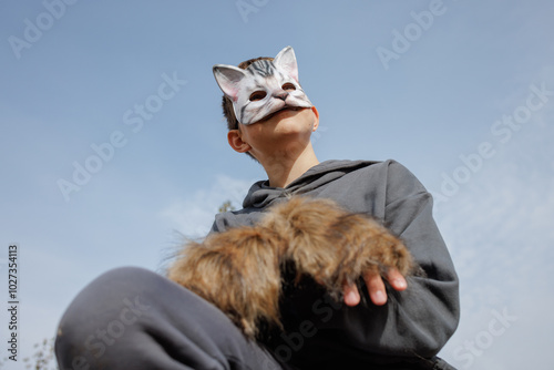 A catmasked teenager performs Quadrobics with gloves mimicking a felines movements photo