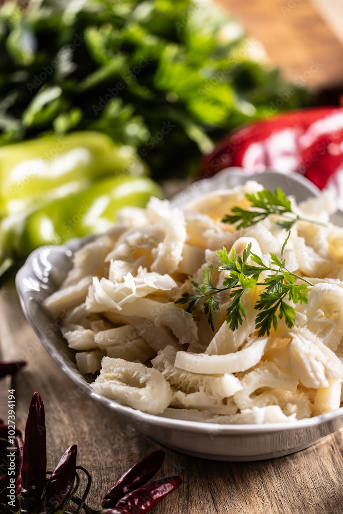 Precooked beef tripes in a bowl with vegetables and herbs ready for cooking Precooked beef tripes in a bowl with vegetables and herbs ready for cooking