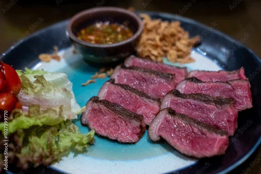 Medium rare sliced Picanha steak meat served on plate with vegetable Medium rare sliced Picanha steak meat served on plate with vegetable