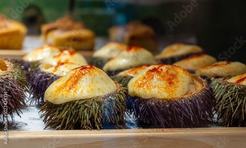 Typical snack of Basque Country, pinchos or pinxtos oven baked sea urchins with goat cheese served in bar in San-Sebastian or Bilbao, Spain, close up photo