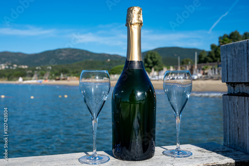 Summer time in Provence, two glasses of cold champagne cremant sparkling wine on famous Pampelonne sandy beach near Saint-Tropez in sunny day, Var department, France, beach club party photo