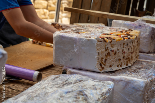 Fresh dessert traditional nougat with chocolate, nuts and fruits on local farmers market in Montellimar, France