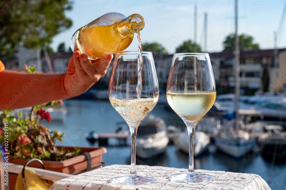 Obraz premium Glasses of cold rose gris Cote de Provence wine in yacht harbour of Port Grimaud, summer vacation on French Riviera in Provence, France, wine tasting