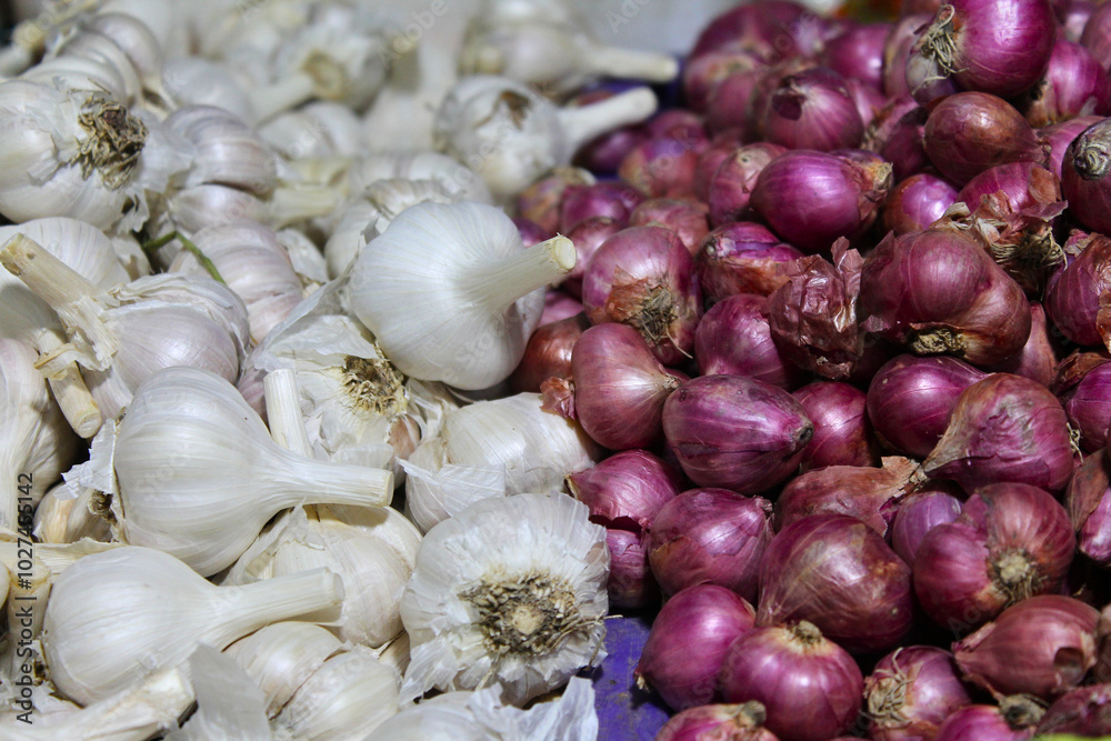 Closeup of pile of garlic and red onions at market. Garlic background. Closeup of pile of garlic and red onions at market. Garlic background.