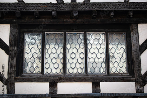 Historic old wooden window frames with glass reflection in historic tudor building