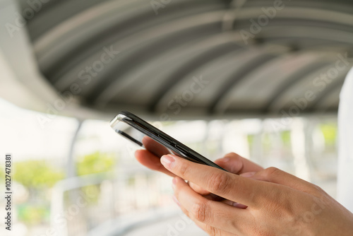 Woman's hands holding smartphone and using a social media at night street.