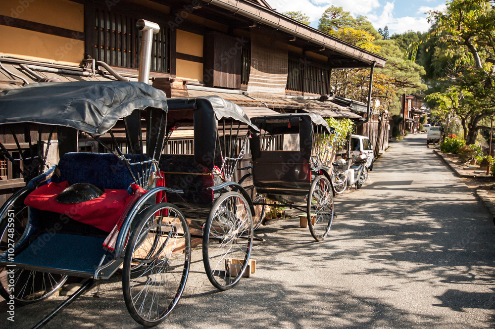 Obraz premium Row of Rickshaw parking next to traditional Japanese houses in Takayama, Japan