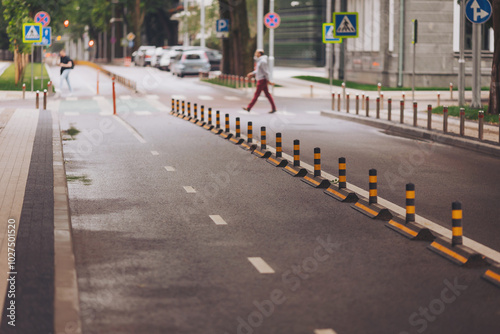 Road with bicycle lanes and pedestrian cross on background. bicycle path and pedestrian crossing on the asphalt in a city street. A protected cycling lane sits on the side of the road . photo