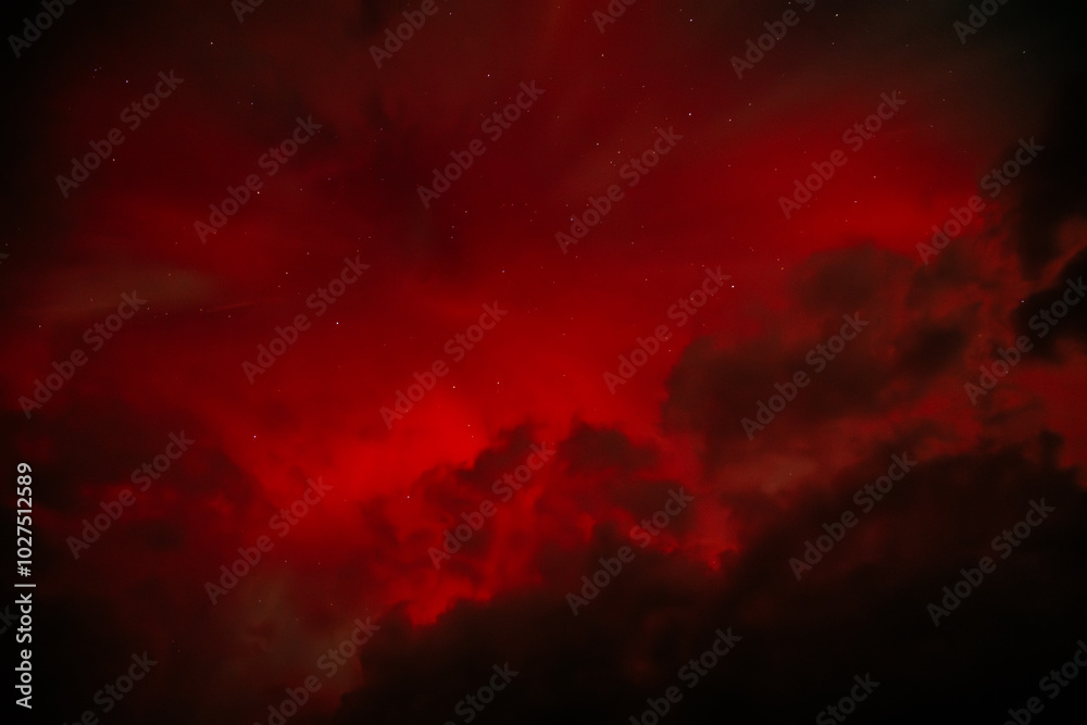A dramatic view of the Aurora Borealis with intense red hues glowing through a cloudy night sky. The vibrant red contrasts with the dark clouds, creating a fiery and mysterious atmosphere. A dramatic view of the Aurora Borealis with intense red hues glowing through a cloudy night sky. The vibrant red contrasts with the dark clouds, creating a fiery and mysterious atmosphere.
