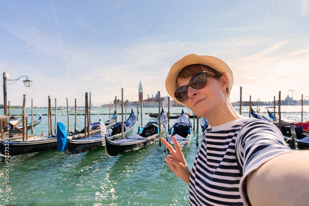 Venice tourist girl on san marco's square taking selfie photo with famous Grand Canal on the background. European tourism attraction in Italy. Young woman on vacation. Venice tourist girl on san marco's square taking selfie photo with famous Grand Canal on the background. European tourism attraction in Italy. Young woman on vacation.