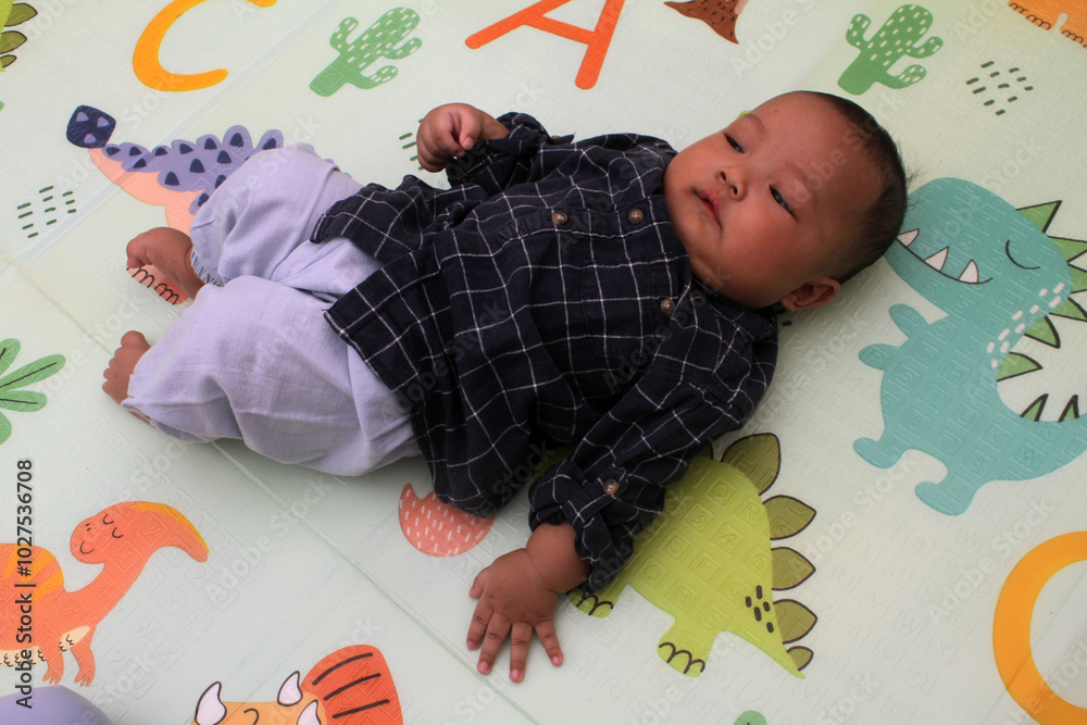 Naklejka premium adorable asian baby boy sleeping on mattress 