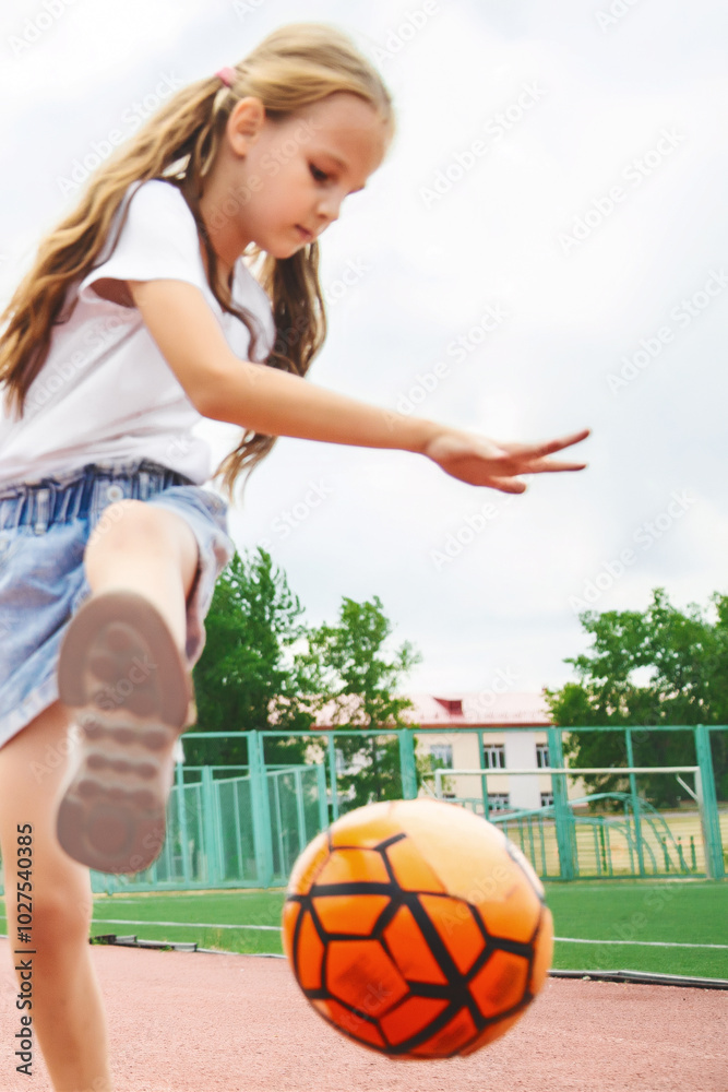 Close up photo young girl playing with ball- dribbling and lifting leg Close up photo young girl playing with ball- dribbling and lifting leg