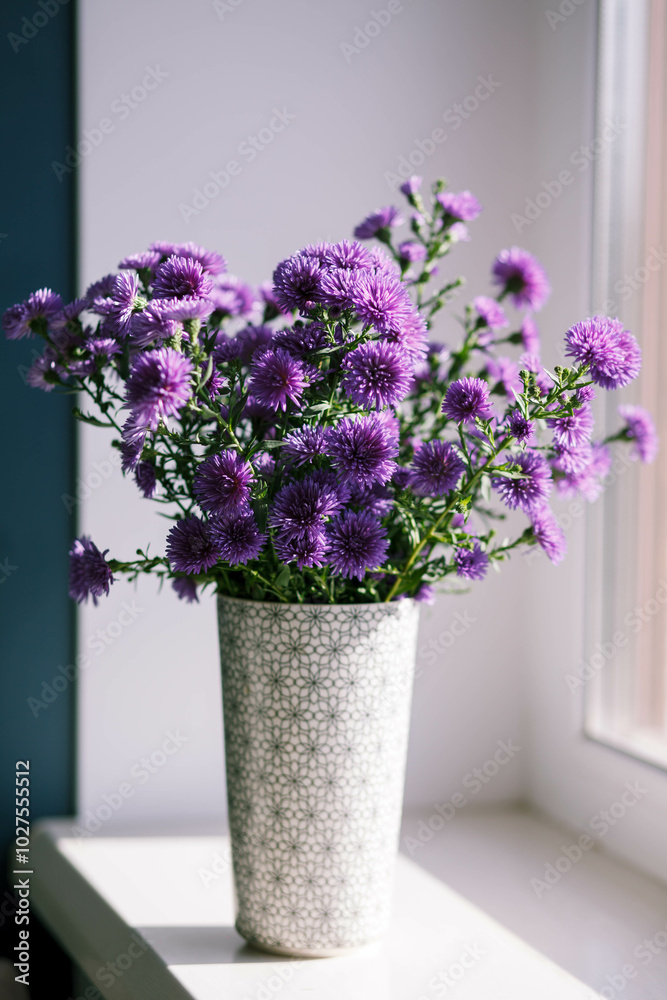 A bouquet of purple chrysanthemums stands in a vase. A bouquet of purple chrysanthemums stands in a vase.