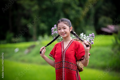 woman carries a large, woven basket on her back filled with white and purple flowers collected from the area nnection with nature, as well as the warmth of a beautiful, natural environment. photo